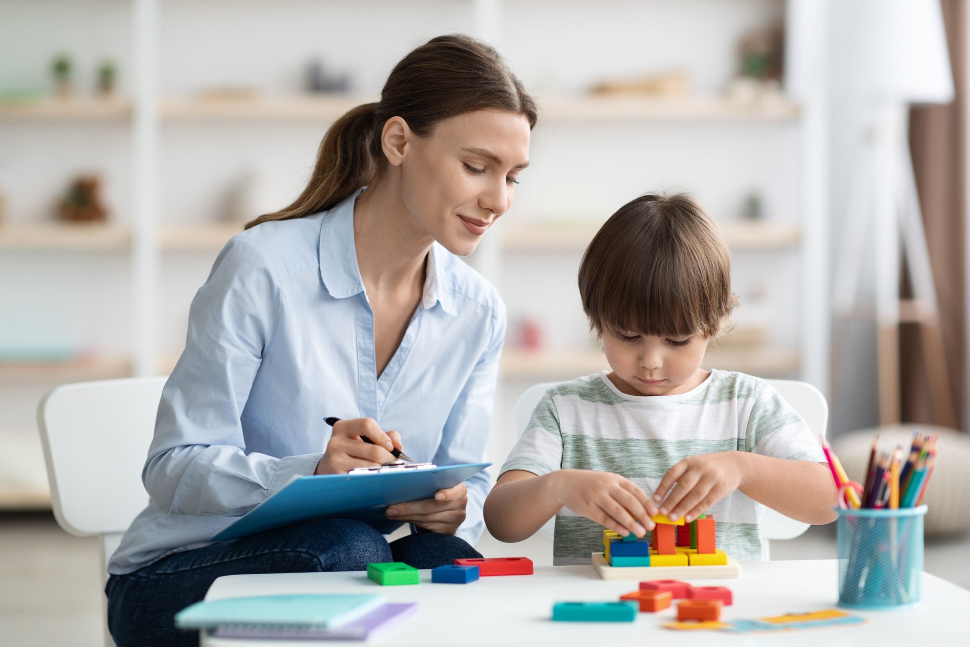 Evaluación del desarrollo mental de los niños. Psicóloga profesional viendo al niño jugando con el juego lógico